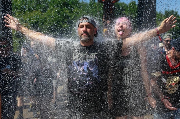 Homme les bras levés se rafraichissant dans un festival